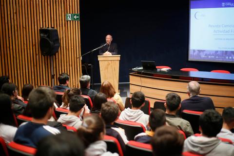 Un orador está dando una charla frente a una audiencia en un auditorio.