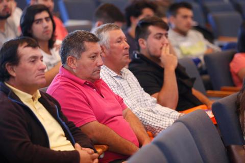 Una audiencia de hombres sentados escuchando atentamente durante un evento.