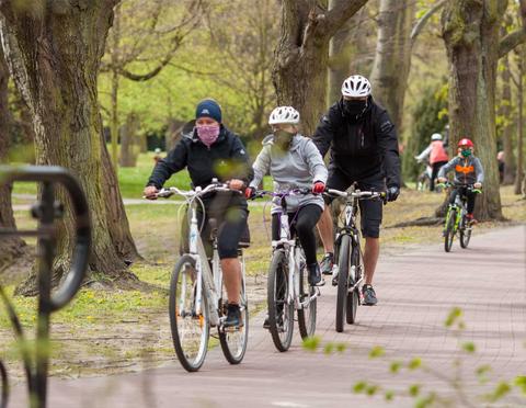 Un grupo de ciclistas recorre un sendero en un parque durante un día fresco.