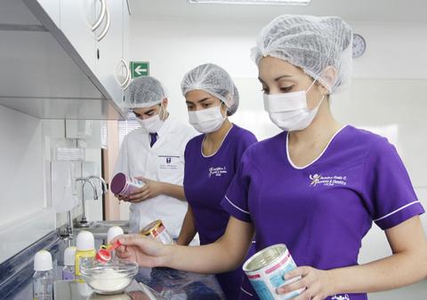 Un grupo de personas en una cocina profesional preparando alimentos.