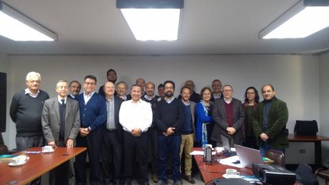Grupo de personas posando en una reunión en una sala de conferencias.