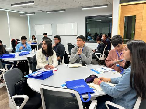Un grupo de estudiantes está prestando atención en una sala de clases moderna.