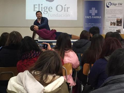 Un grupo de estudiantes observa una demostración sobre cuidados de salud en un aula.