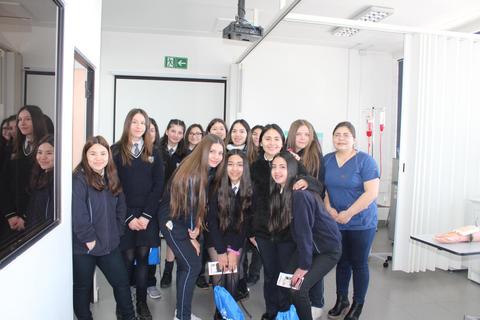 Un grupo de estudiantes sonrientes posando en un aula.