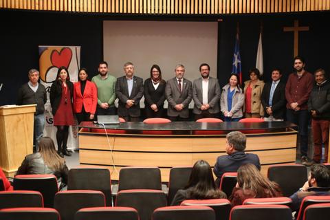 Un grupo de personas posando en un evento formal en un auditorio.