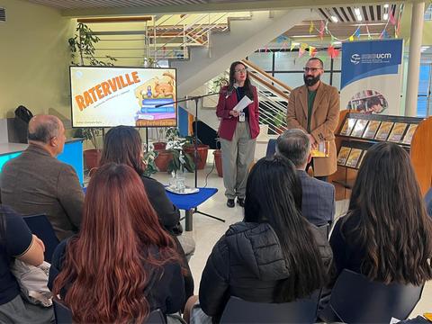 Una presentación en un evento educativo sobre Raterville con un público atento.