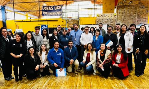 Un grupo diverso de personas posando en un gimnasio durante un evento comunitario.