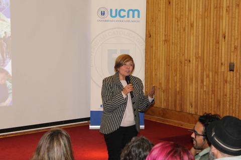 Una mujer habla a una audiencia en un evento en la universidad.