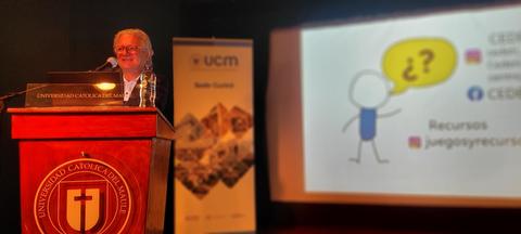 Un ponente presenta un recurso en una conferencia ante un público en una universidad.