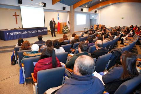 Una conferencia en la Universidad Católica del Maule con una audiencia atenta.