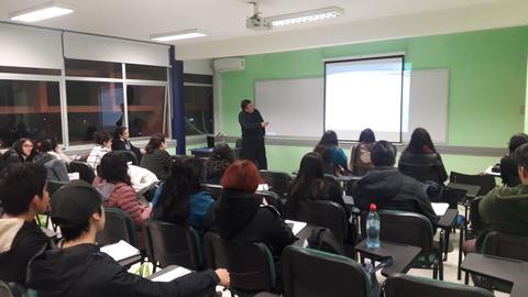 Un aula llena de estudiantes atentos a una presentación.