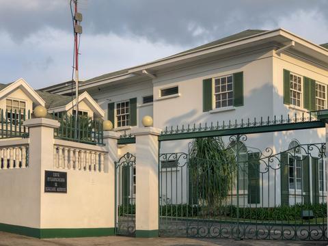 Una casa elegante con un diseño clásico y un hermoso jardín en la entrada.