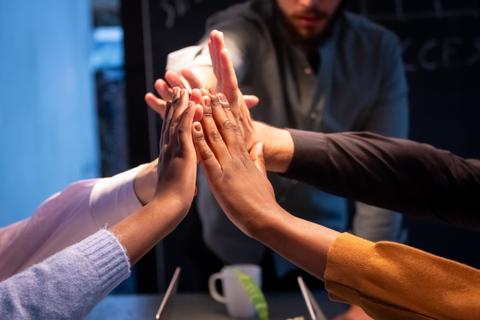 Un grupo de personas se une en un acto de colaboración y apoyo mutuo.