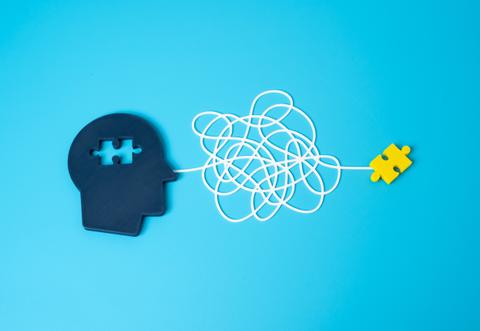 Una representación creativa de un cerebro con un rompecabezas y un hilo enredado que simboliza el pensamiento.