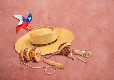 Un sombrero de paja junto a juegos tradicionales chilenos como el trompo y el yo-yo.