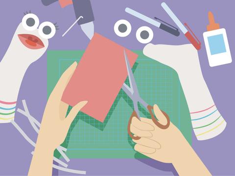 Una mesa de manualidades con materiales para crear títeres de calcetín.