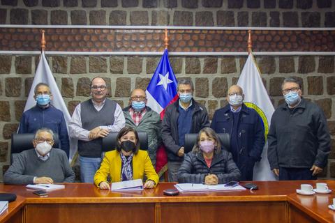 Una reunión de grupo en un ambiente institucional con participantes usando mascarillas.