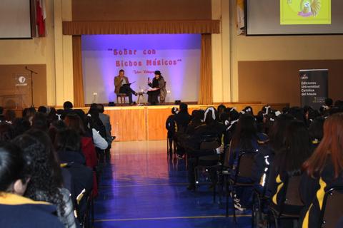 Una charla en un evento educativo con un público atento en un auditorio.