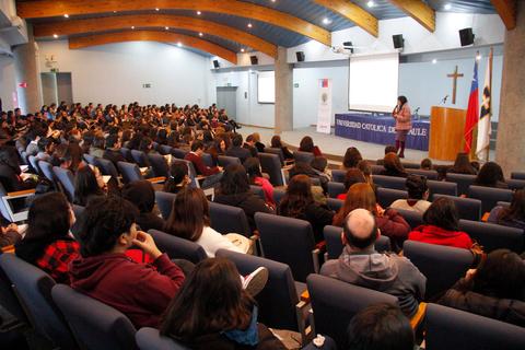 Una conferencia con un gran número de asistentes en un auditorio universitario.