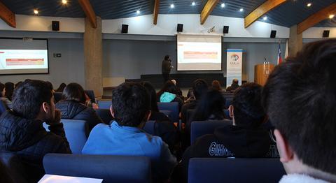 Un grupo de estudiantes asiste a una presentación en un auditorio.
