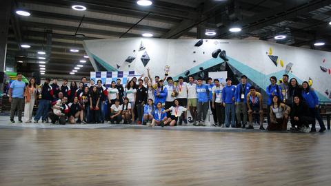 Un grupo grande de escaladores celebra un evento en una sala de escalada.