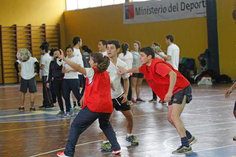 Un grupo de jóvenes participa en una actividad deportiva en un gimnasio.