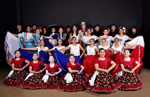 Un grupo de bailarines vestidos con trajes tradicionales, posando en una formación colorida.