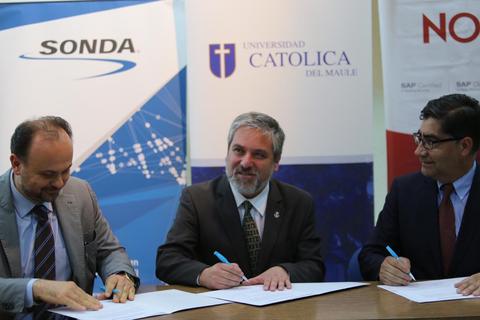 Tres personas firmando un acuerdo en un evento oficial.