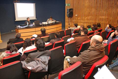 Una conferencia en un auditorio con varias personas atentas al ponente.