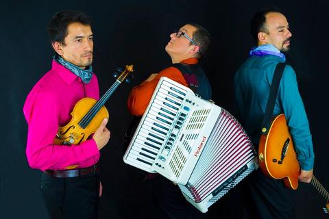 Tres músicos posan con sus instrumentos en un fondo negro.