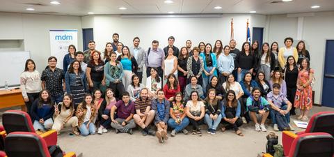 Un grupo de personas posando juntas en un evento en un salón de clases.