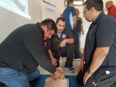 Un grupo de personas está realizando un entrenamiento en reanimación cardiopulmonar (RCP).
