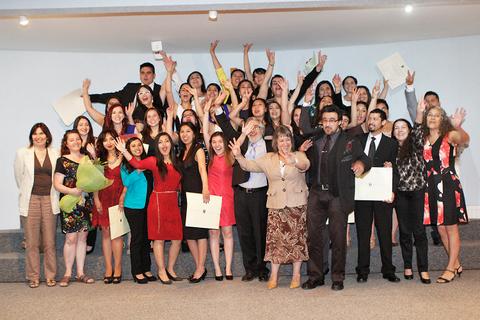 Un grupo de jóvenes celebra su graduación con sonrisas y gestos de alegría.