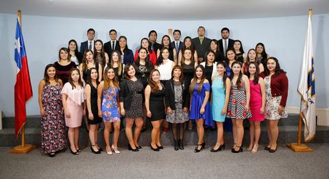 Un grupo de personas posando en un evento formal en un ambiente interior.