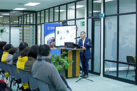 Un hombre está dando una presentación frente a un público en una sala de conferencias.