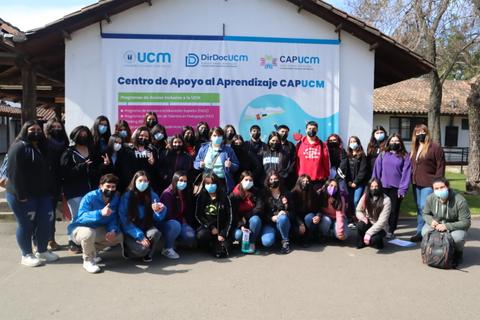 Grupo de estudiantes posando frente a un cartel del Centro de Apoyo al Aprendizaje CAPUCM.