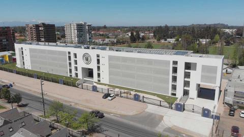Edificio moderno y amplio que alberga diversas instalaciones en un entorno urbano.