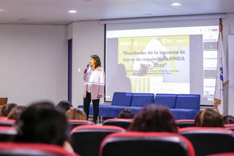 Una mujer presenta los resultados de una encuesta en una conferencia.