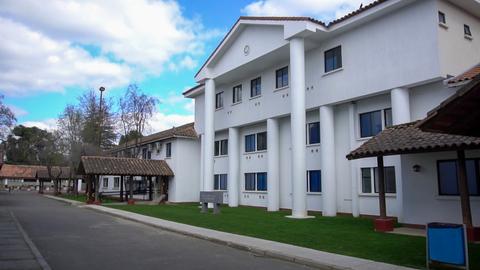 Edificio moderno rodeado de áreas verdes y un cielo nublado.