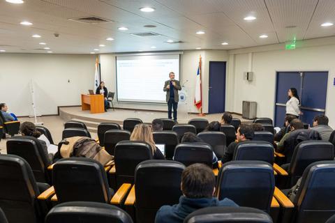 Un conferencista presenta ante un público en una sala de conferencias.