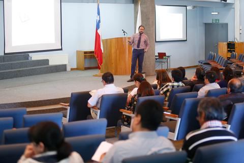 Un hombre está dando una presentación ante un público en un auditorio.