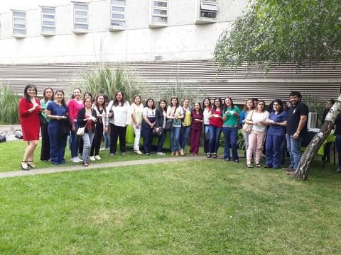 Un grupo de personas sonrientes posando en un jardín.