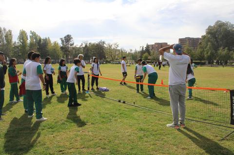 Un grupo de personas participa en una actividad deportiva al aire libre en un parque.
