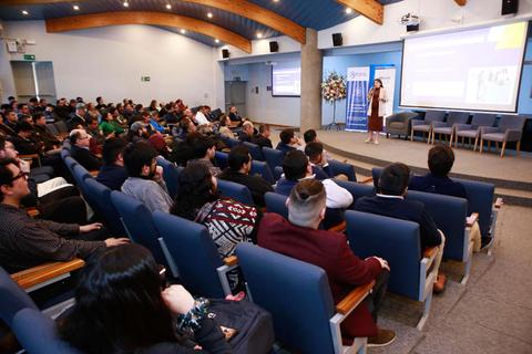 Una presentación en un auditorio lleno de gente interesada en escuchar.
