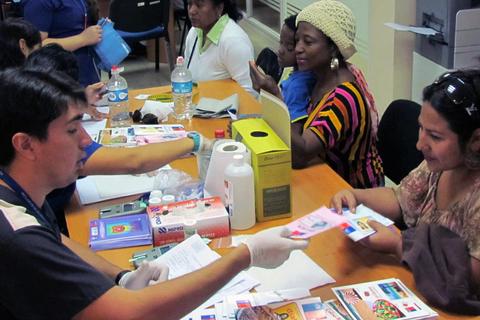 Un grupo de personas participa en una actividad de distribución y educación en una mesa.