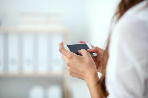 Una persona sostiene un teléfono móvil en sus manos.