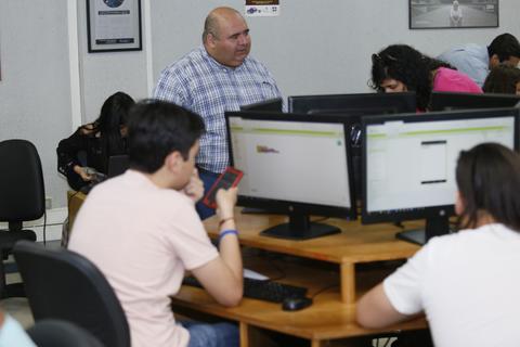 Un grupo de personas trabajando en computadoras en un ambiente de oficina.