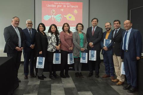 Un grupo de personas posando en un evento en apoyo a la infancia.