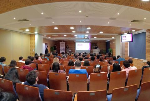 Una sala llena de personas asistiendo a una presentación en un evento.