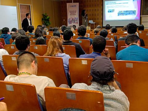 Un grupo de personas asiste a una conferencia en un auditorio.